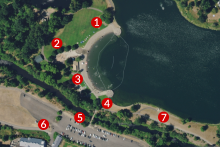 An aerial view of Klineline Pond with seven red dots labeled with white numbers one through seven, showing locations of geotechnical surveying around the pond, near the playground, near the picnic area, near the fishing pier, and near the trail and parking lot. 