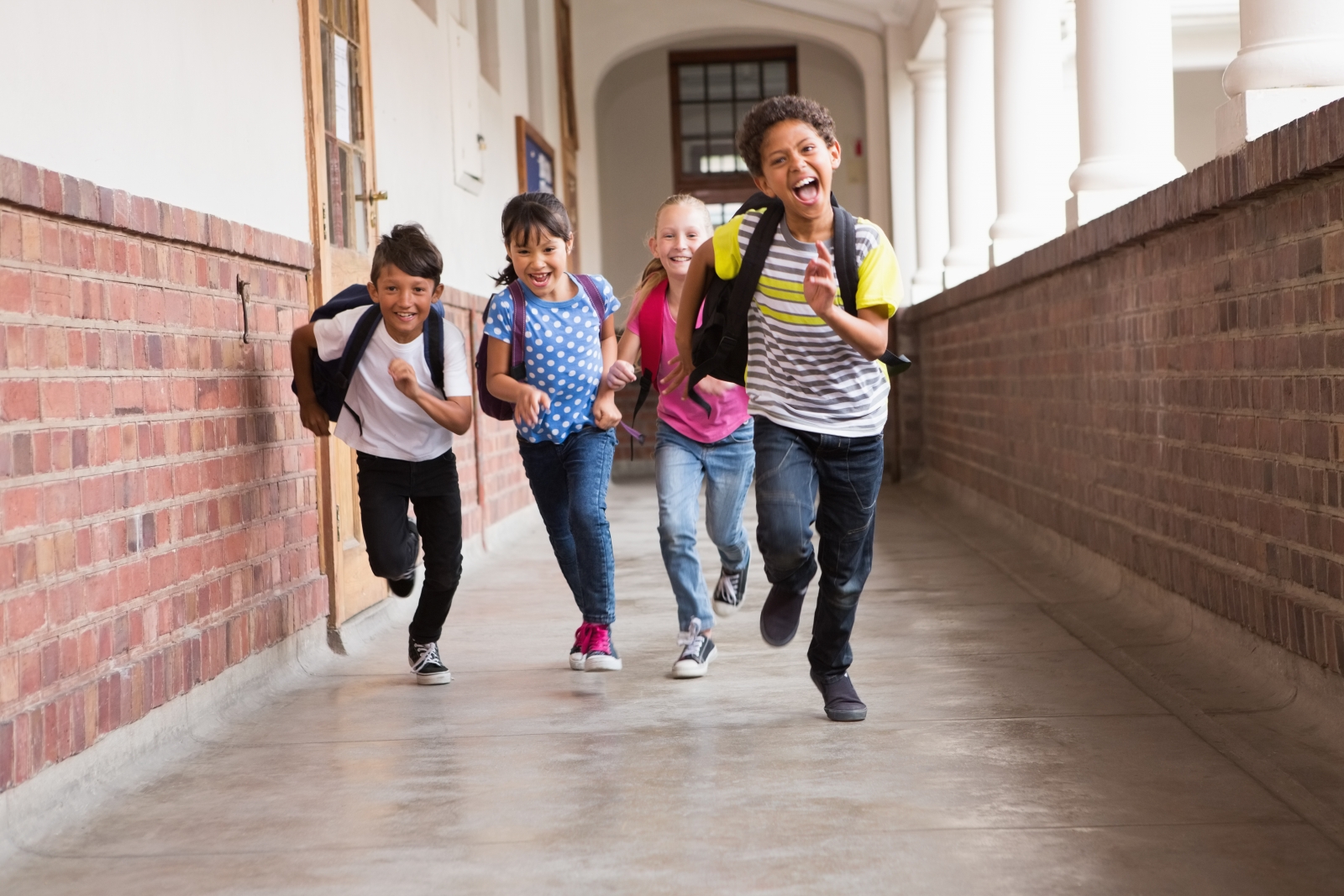 kids running towards camera down school hallway
