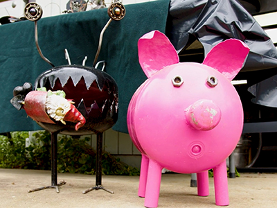 Whimsical pink pig and crab metal sculpture by artist Wayne Deaton