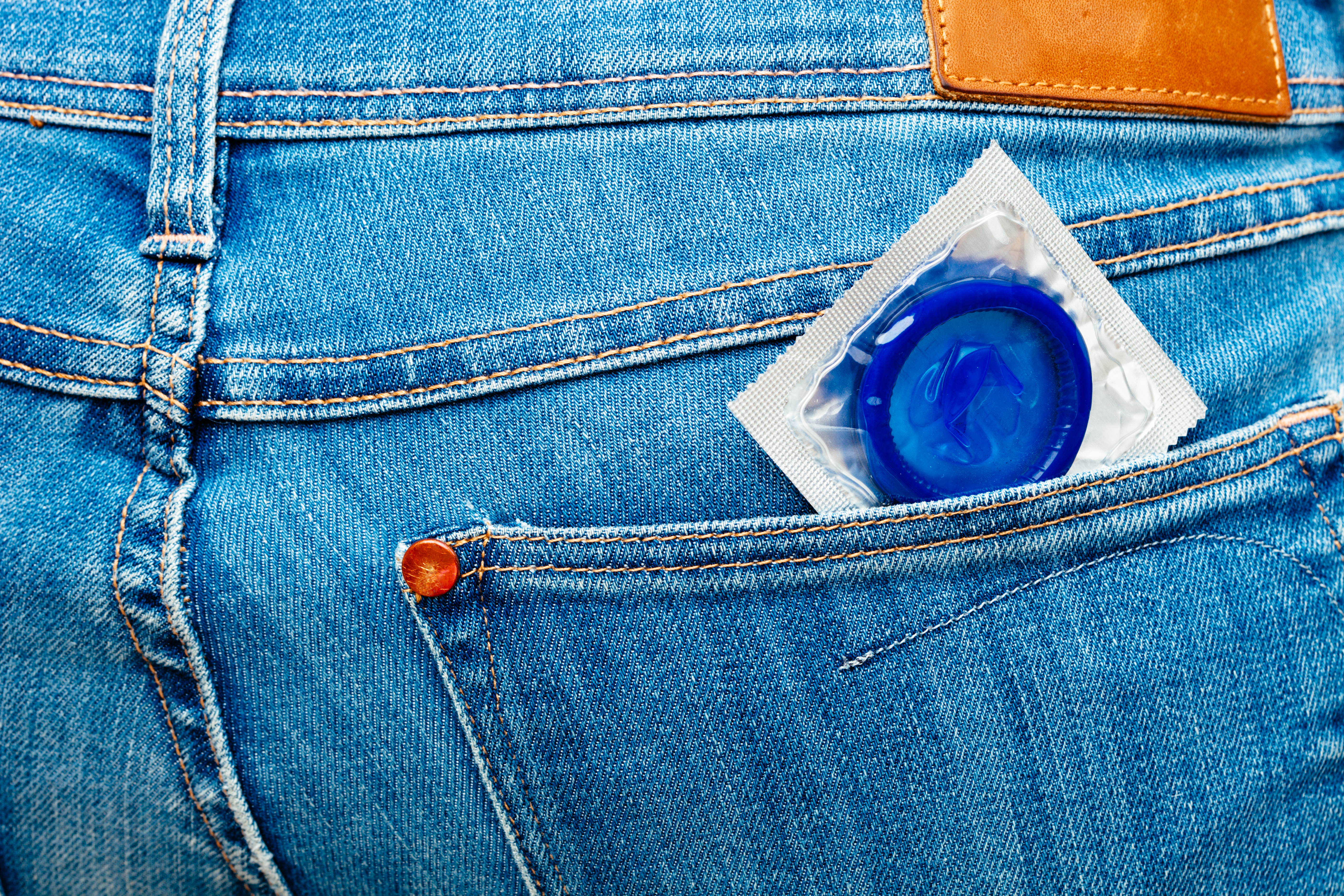 Blue condom in jeans pocket