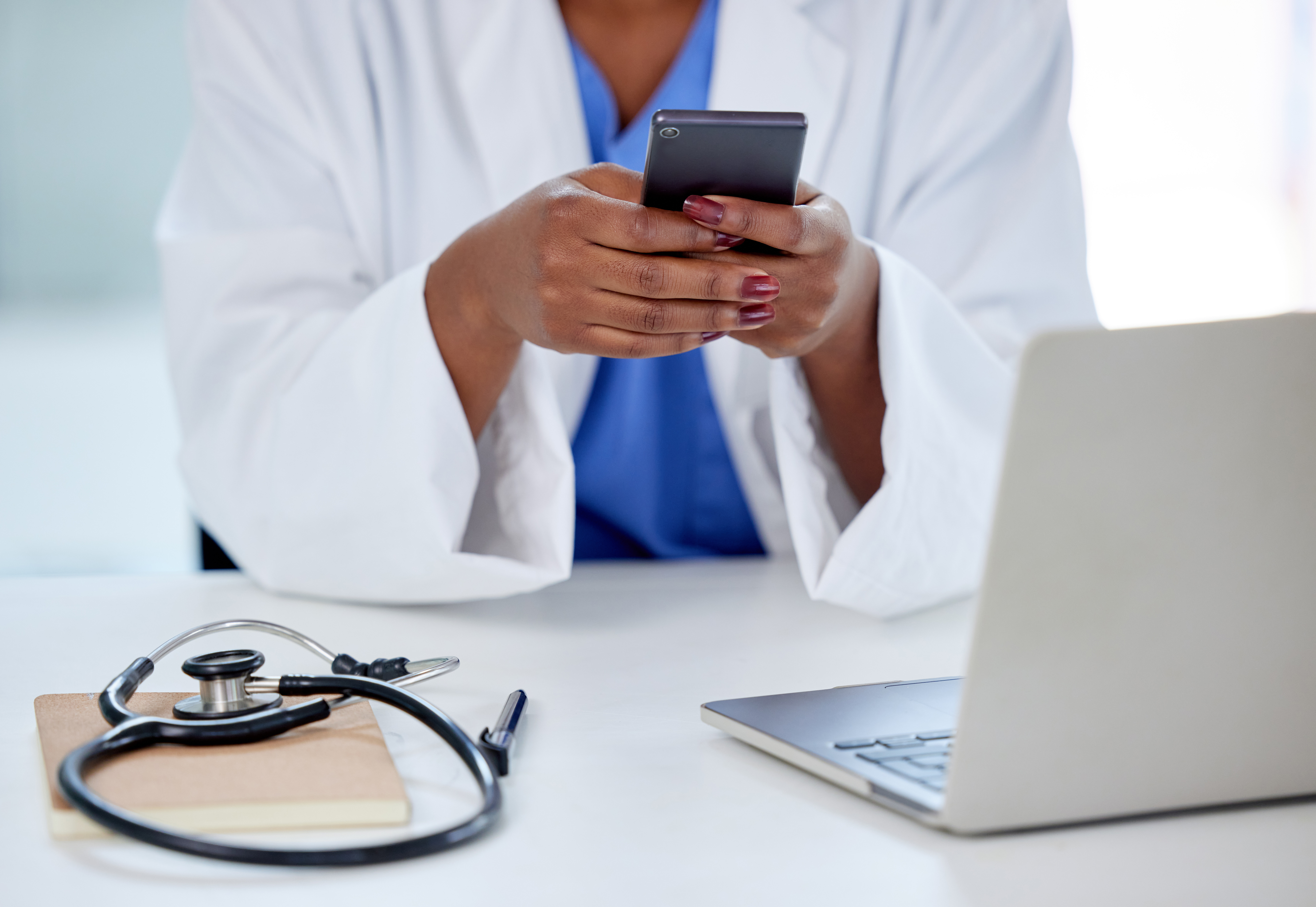 Doctor entering information into a mobile phone
