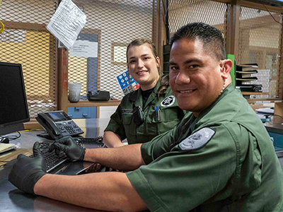 Male and female corrections deputies sitting at computer in the Clark County Jail
