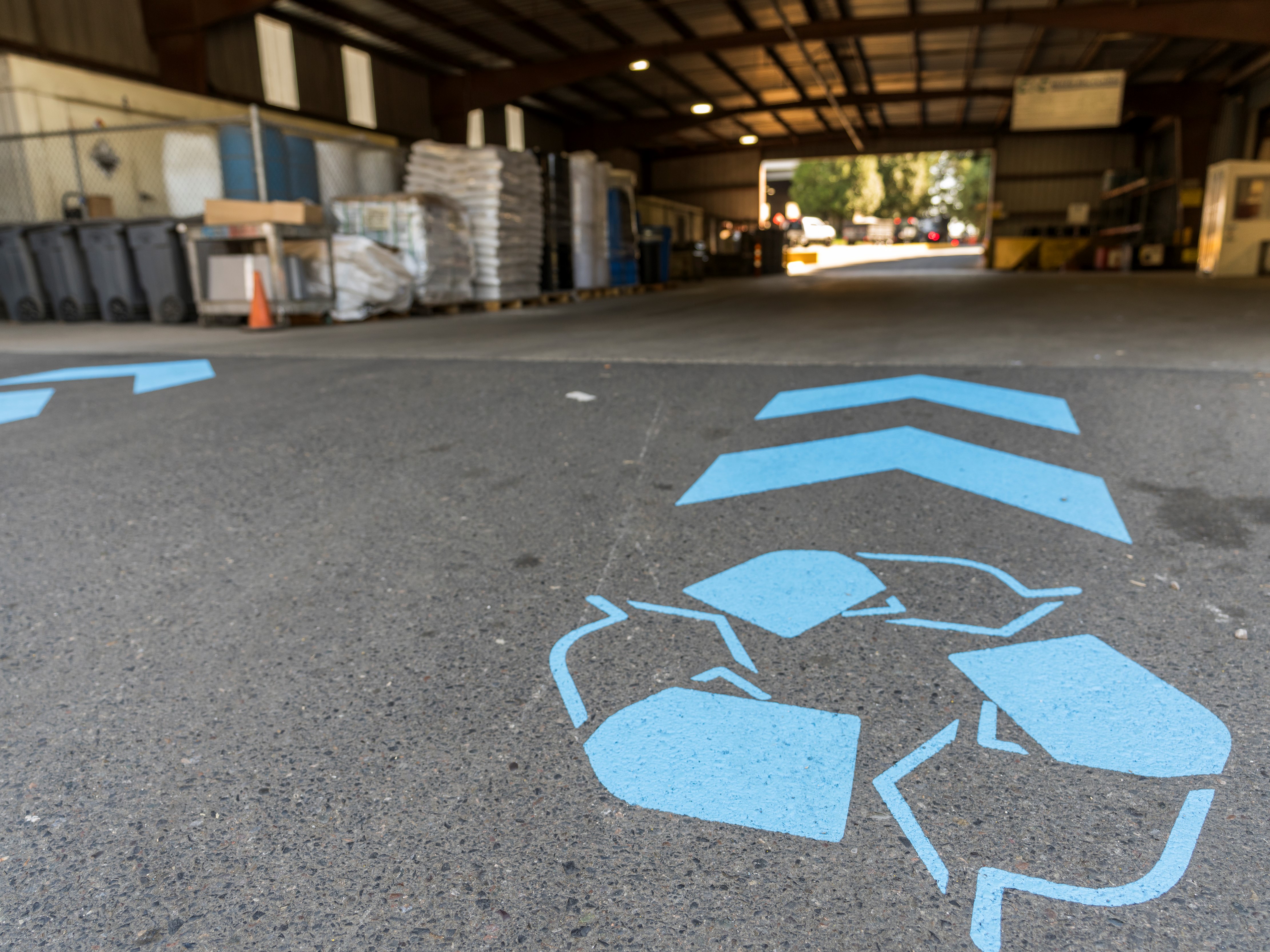 Floor painted recycling symbol and directional arrows